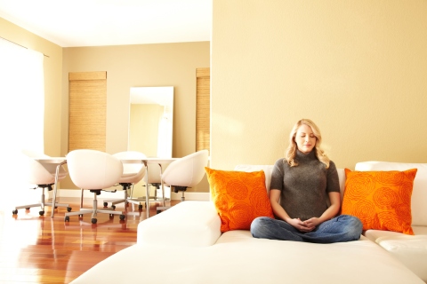 Woman meditating at home and observing Feng Shui practices for better overall well-being.